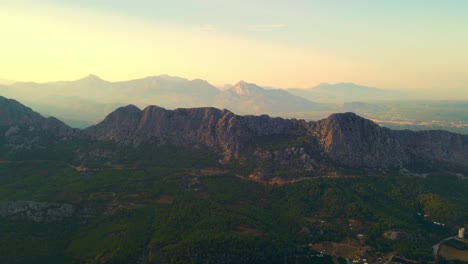 Aerial-4K-drone-video-of-a-sunset-panorama-of-mountain-ridge-near-Antalya,-Turkey,-view-from-Mount-Tunektepe,-Tunektepe-Teleferik-on-a-summer-day-and-mountains-near-Antalya-city