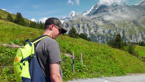 A-tourist-with-a-backpack-takes-a-moment-to-look-at-the-beauty-of-the-Hineres-Lauterbrunnen-valley-in-Switzerland