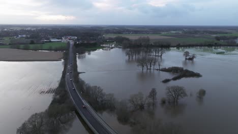 Cars-drive-over-a-flooded-river-in-Lower-Saxony-near-Lingen,-Ems