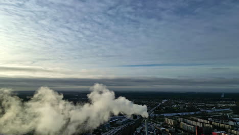 Smoke-Flowing-Out-Of-A-High-Chimney-Stack-At-The-Industrial-Area-In-A-City
