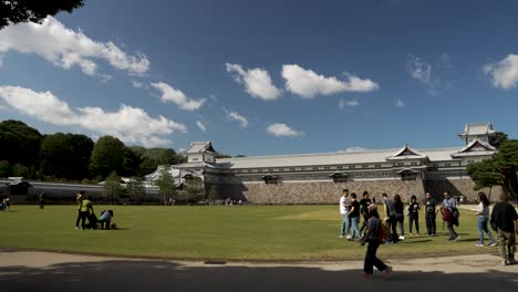 Tourists-On-Park-Lawn-In-Front-Of-Gojukken-Nagaya---Kanazawa-Castle-On-Sunny-Afternoon-Day