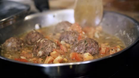 turning-and-cooking-meatballs-in-a-steel-pan-Preparing-ingredients-to-make-vegan-beyond-meatballs-with-spaghetti-and-meat-sauce