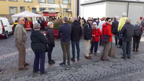 Group-of-people-queueing-at-Bæjarins-Beztu-Pylsur-stand,-a-traditional-and-famous-street-food-in-Reykjavik,-Iceland