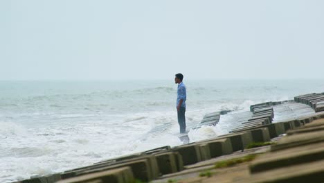Beauty-and-danger-of-nature-as-man-watches-the-waves-crash-in-on-him