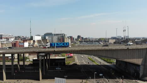 Blue-Tesco-truck-passes-over-Kingston-bridge-motorway,-Glasgow,-Scotland,-UK