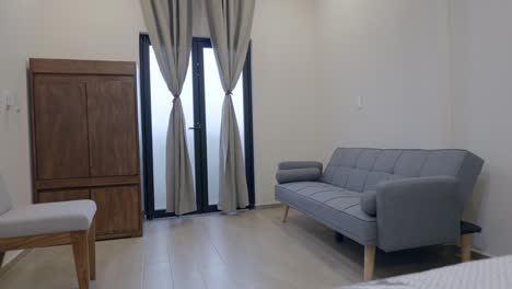 Minimalistisches-Interieur-Eines-Hotelzimmers-Mit-Stuhl,-Holzschrank-Und-Couch