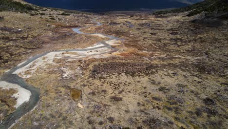 Drone-shot-flying-over-marshland-near-the-Laguna-Esmeralda-panning-up-to-reveal-the-Andes-mountains