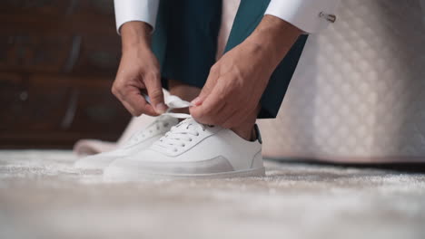 Person-Tying-Laces-on-White-Sneakers