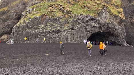 People-walking-at-Reynisfjara-Black-Sand-Beach-on-a-rainy-day-in-Southern-Iceland