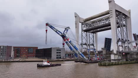 Industry-crane-pulled-through-and-beneath-the-towering-railway-bridge