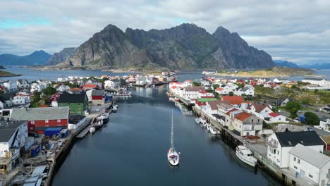 Barco-Navega-En-El-Puerto-De-Henningsvaer,-Isla-De-Lofoten,-Noruega,-Escandinavia---Antena-4k