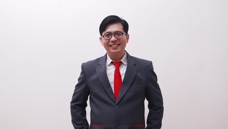 Asian-businessman-standing-while-smiling-looking-at-the-camera