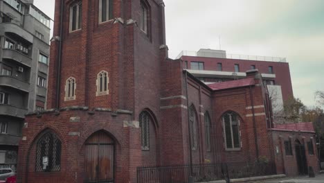 Tilt-up-shot-of-a-red-brick-church-in-Bucharest-on-an-overcast-day