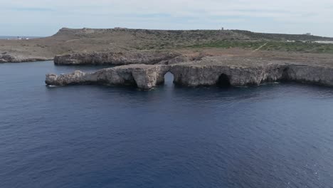 Drohne-Fliegt-Bei-Sonnenuntergang-Um-Die-Klippen-Von-Port-Den-Gil-Entlang-Der-Spektakulären-Küste-Von-Menorca