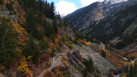 Cinematic-drone-aerial-4wd-truck-off-road-Marble-Crystal-Mill-stunning-autumn-Aspen-fall-colors-Southern-Colorado-Rocky-Mountains-peaks-Ouray-Telluride-camping-hiking-river-yellow-trees-follow-forward