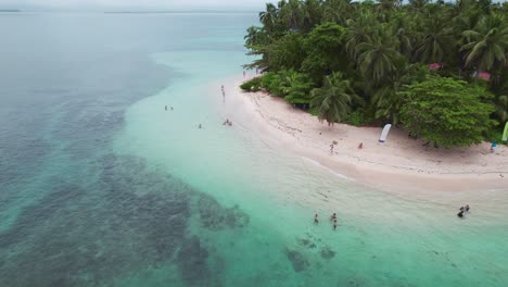 Drone-view-of-many-tourist-swim-at-Zapatilla-Cay-beach-in-Bocas-del-Toro,-Panama_4K