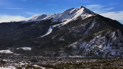 Snowy-Downtown-Frisco-i70-Colorado-aerial-cinematic-drone-Lake-Dillon-Marina-Summit-cove-sun-cloudy-winter-morning-view-Silverthorne-Ten-Mile-Range-Breckenridge-calm-frozen-ice-backwards-reveal