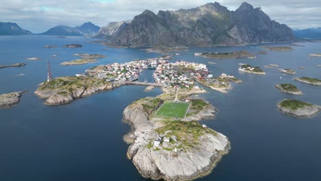 Henningsvaer-Soccer-Field-and-Village-in-Lofoten-Island-Archipelago,-Norway---4k-Aerial-Tilting-Down