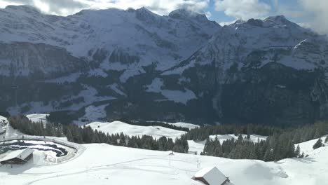 Luftdrohne-Vorwärtsbewegende-Aufnahme-über-Der-Schneebedeckten-Bergkette-Der-Engelberg-Brunni-Bahnen-Entlang-Der-Schweizer-Alpen-In-Der-Schweiz-An-Einem-Wintermorgen
