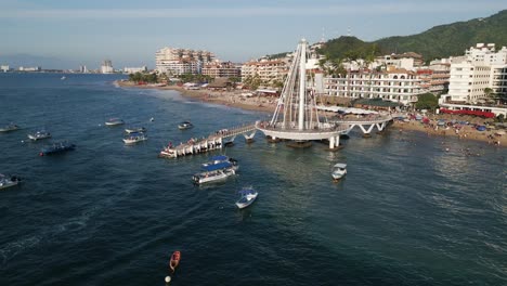 Aerial-Drone-Zoom-Out-Pier-Boats,-Puerto-Vallarta-Mexican-Beach-Town,-Blue-Ocean-in-Pacific-Coastline