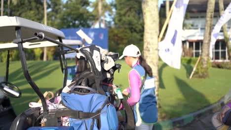 Caddy-prepares-the-golfer's-clubs-to-the-golf-cart-before-playing