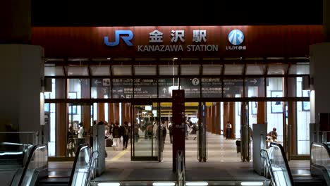 East-Entrance-To-JR-Kanazawa-Station-At-Night-With-Commuters-Walking-Through-Concourse