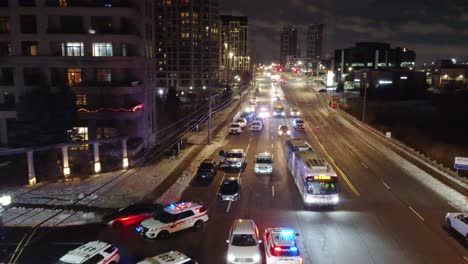 Luftdrohne-Fliegt-Nachts-über-Polizeiautos,-Lastwagen-Patrouillieren-Mit-Rot-blauen-Lichtern-In-Ontario,-Kanada