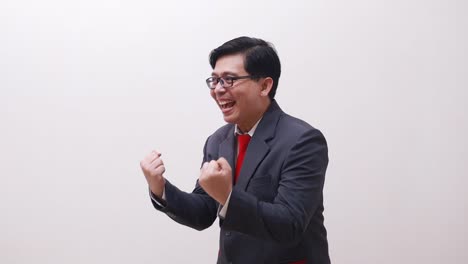Wow-excited-asian-businessman-standing-while-celebrating-his-success-with-fist-or-clenching-hands