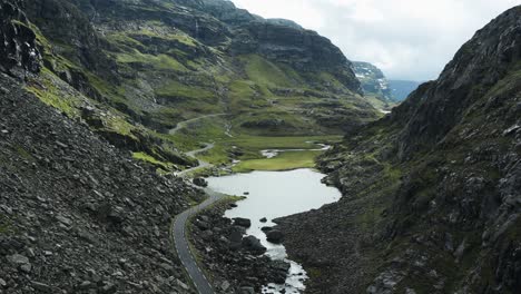 A-narrow-road-winds-through-the-Norwegian-rocky-mountainous-landscape