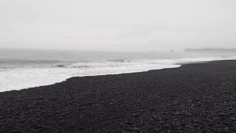 Black-Sand-Beach,-Reynisfjara-Beach,-Iceland-in-rainy-autumn---Panning-shot
