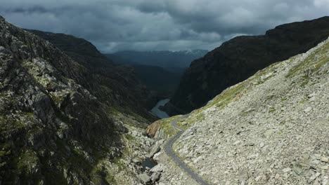 Una-Estrecha-Carretera-Asfaltada-Serpentea-A-Través-Del-Rocoso-Valle-Noruego-De-Roldalsfjellet