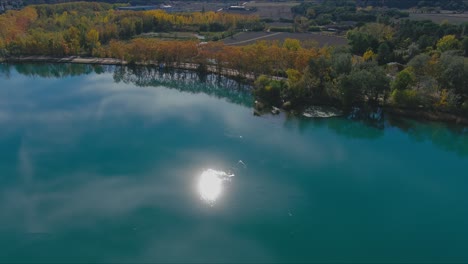 Der-Banyoles-See-Im-Herbst-Spiegelt-Den-Blauen-Himmel,-Die-Sonne-Und-Die-Bäume-In-Girona-Wider