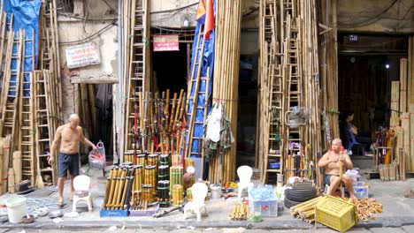 Skilled-shirtless-locals-take-break-from-crafting-bamboo-smoking-pipes