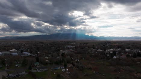 Rising-drone-shot-of-a-rural-city-in-Idaho-with-sunlight-rays-in-the-distance