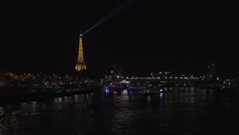 Beleuchteter-Eiffelturm-Bei-Nacht-Mit-Blick-Auf-Die-Seine-Und-Die-Stadt-Paris