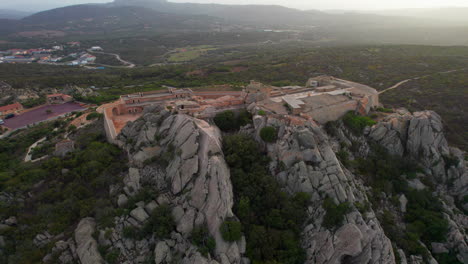 La-Fortezza-di-Monte-Altura,-Sardinia:-Aerial-view-in-mid-orbit-and-during-sunset-over-this-beautiful-fortress-on-the-island-of-Sardinia