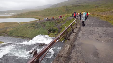 Touristen-Erkunden-Den-Wasserfall-Kirkjufellsfoss-In-Island-An-Einem-Windigen-Herbsttag-In-Island---Schwenk