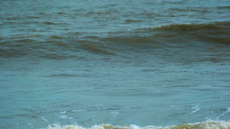 Close-up-shot-of-Sea-waves-splash-on-the-beach---Turquoise-blue-sea-waves-splash-at-the-beach