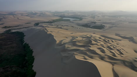 Front-Aerial-Dolly-Sand-Dunes-Laguna-de-Morn-Peru-Foggy-Sky-Sunset