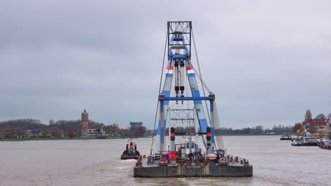 Rear-view,-Tug-boat-and-floating-crane-together-they-navigate-the-waterway