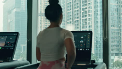Business-woman-uses-treadmill-in-the-office-with-view-on-city