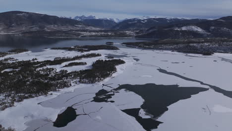 Downtown-Frisco-toward-Keystone-Colorado-aerial-cinematic-drone-Lake-Dillon-Marina-Summit-cove-cloudy-snowy-winter-morning-view-Silverthorne-Ten-Mile-Range-Breckenridge-calm-unfrozen-ice-forward