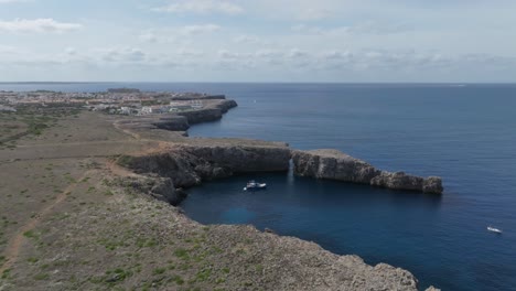 Drone-flying-around-the-cliffs-of-Port-den-Gil-at-sunset-along-the-spectacular-coastline-of-Menorca