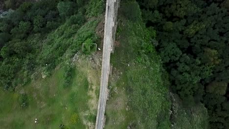 Drone-shot-following-the-path-of-the-water-of-the-viceregal-aqueduct-rotating-with-a-perspective-of-"Arcos-del-Sitio"-in-Tepotzotlan,-State-of-Mexico,-Mexico