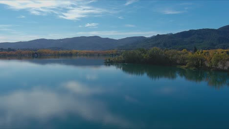 Lake-Banyoles-reflects-sky-and-trees-around-it-in-autumn