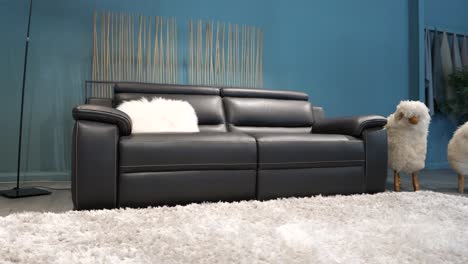 Slow-arching-shot-of-a-black-leather-couch-for-sale-in-a-sofa-shop