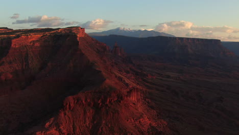 Aerial-cinematic-drone-Moab-Utah-dramatic-red-orange-sunset-mountain-snow-covered-peak-The-Big-Enchilada-landscape-Arches-National-Park-Castle-Valley-Castleton-Fishers-Tower-Green-River-camping-left