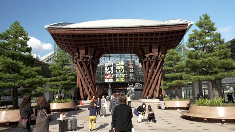 Tourists-taking-pictures-of-the-Tsuzumi-Drum-Gate-of-Kanazawa-Station,-architectural-landmark