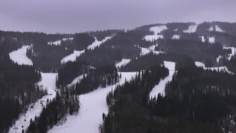 Cinematic-Colorado-ski-trails-zoomed-in-gondola-ski-lifts-aerial-drone-cloudy-snowy-winter-December-Christmas-Keystone-Ski-Resort-Epic-Local-Pass-entrance-Rocky-Mountain-Breckenridge-Vail-circle-left