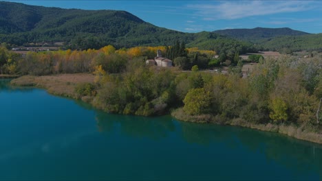 Aerial-View-Of-Lake-Banyoles-And-Santa-Maria-De-Porqueras-Church,-Girona